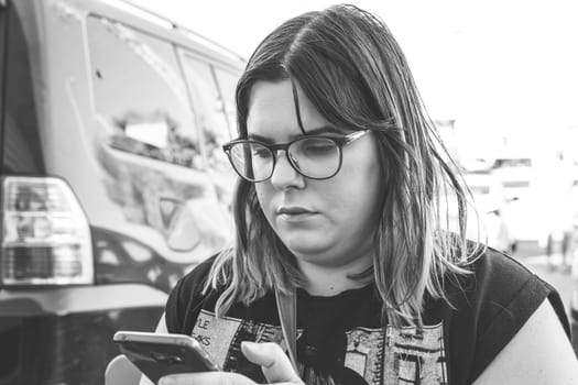 Woman using smartphone on the street. Close up black white image.