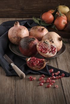 Pomegranate fruit on rustic table in vintage style.