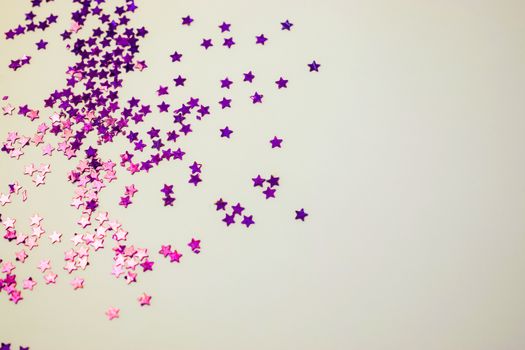 Purple glitter stars on a white background with copy space