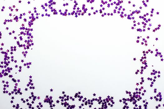 Purple glitter stars on a white background with copy space