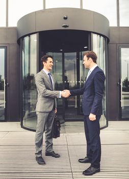 Business people shaking hands outdoor office building