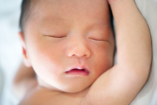 Close up cute Asian newborn baby sleeping, 7 days old.