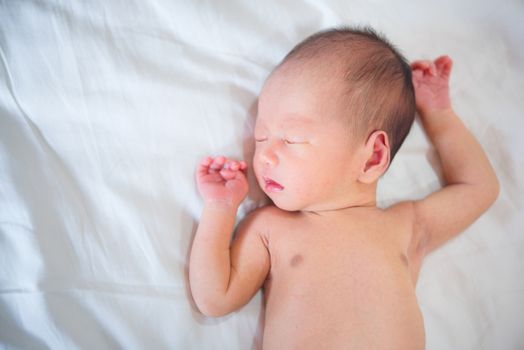 Asian newborn baby boy sleeping with tenderness, 1 week old.