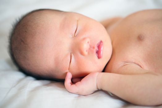 Sleeping Asian newborn baby boy, 1 week old.