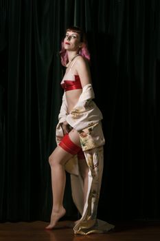 Girl with red vintage lingerie and kimono next to velvet curtains.