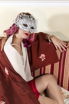 Girl with red vintage lingerie with a striped sofa in the living room.