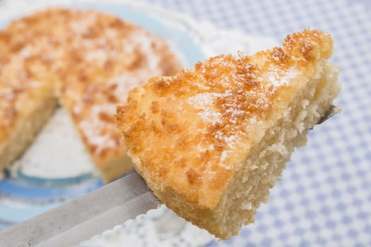 Close up view of sliced piece of  a tasty coconut crumble cake.