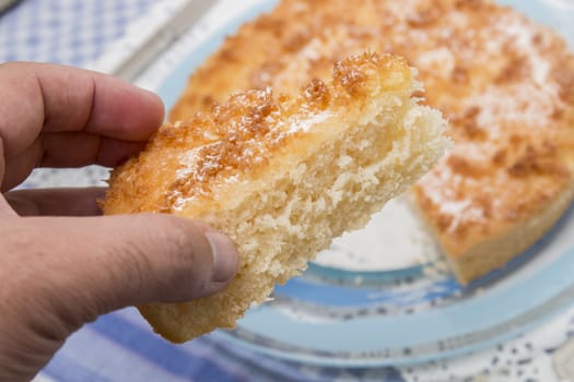 Close up view of sliced piece of  a tasty coconut crumble cake.