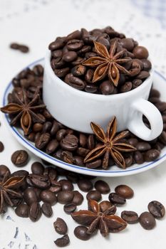 Composition of a cup full of coffee beans on table.