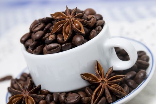 Composition of a cup full of coffee beans on table.
