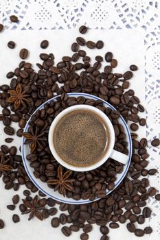 Composition of a coffee cup with spreaded beans and star anise.