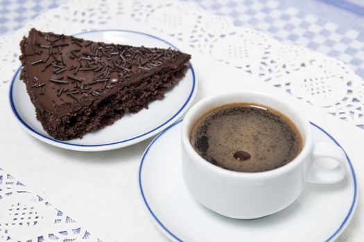 Composition of the classic coffee cup espresso with a piece of brigadeiro cake.