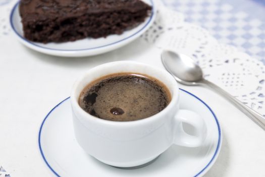 Composition of the classic coffee cup espresso with a piece of brigadeiro cake.