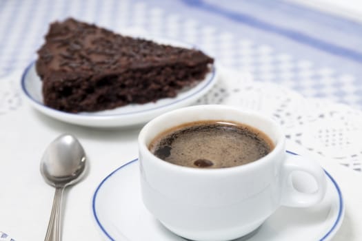 Composition of the classic coffee cup espresso with a piece of brigadeiro cake.