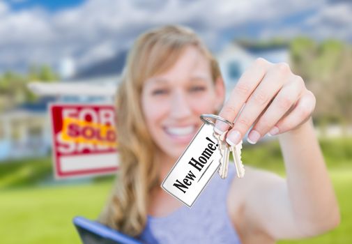 Woman Holding New House Keys with New Home Card In Front of Sold Real Estate Sign and Home.