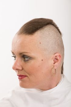 Portrait of beautiful middle age woman patient with cancer with partially shaved head like punk, hope in healing. She lost her hair