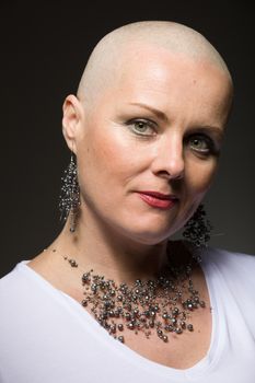 Portrait of beautiful middle age woman sad patient with cancer with shaved head without hair, hope in healing.