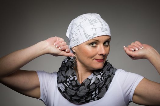 Portrait of beautiful positive smiling middle age woman patient with cancer wearing headscarf, hope in healing