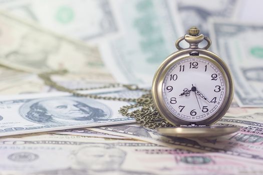 Classic pocket watch on dollar banknote, concept and idea of time value and money, business and finance concepts.