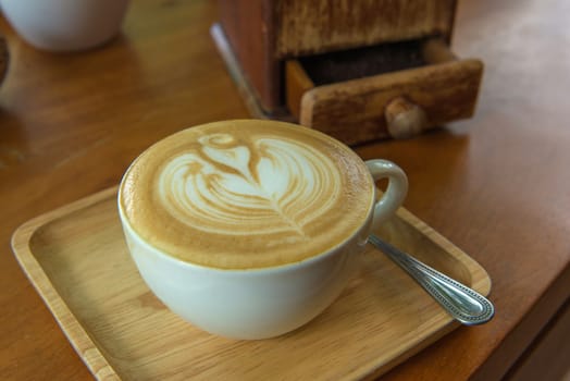 latte art coffee or cappuccino on wooden table background.