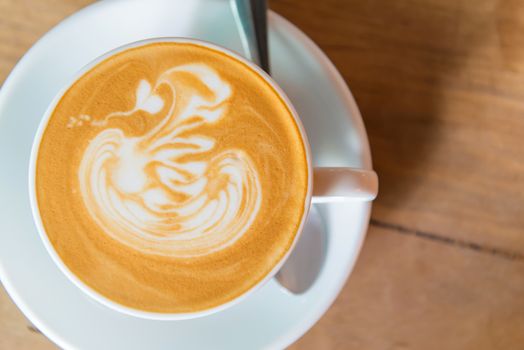 latte art coffee or cappuccino on wooden table background.