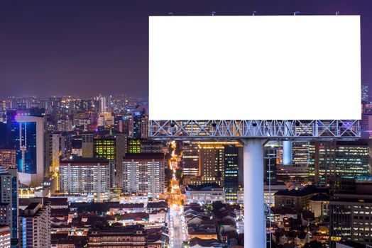 Blank billboard for advertisement in city downtown at night.