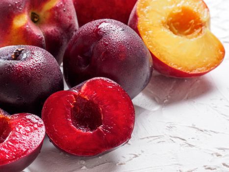 Close up view of fresh plum and peach on white concrete background. Copy space.