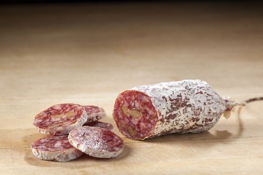 Delicious dry sausage with walnuts on wood