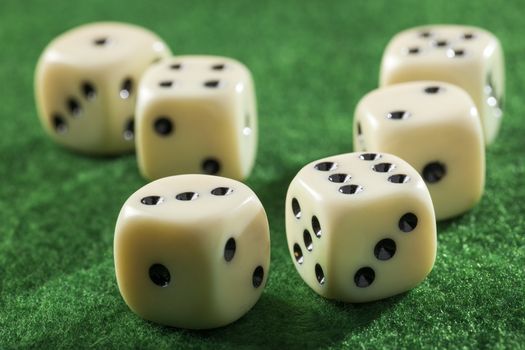 Six dices on a green felt table