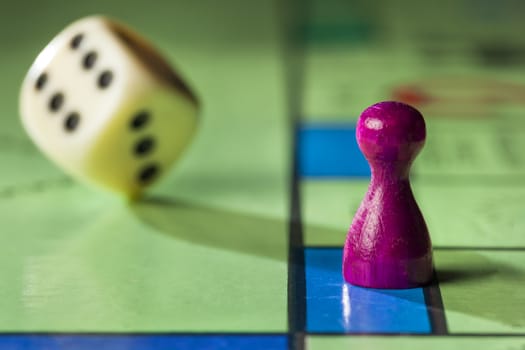 Close up of a board game with pawn and  rolling dice