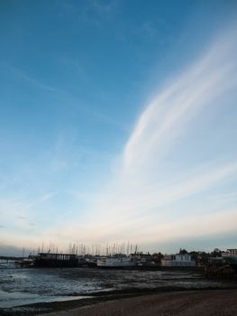 row of beach front marina houses with big open blue sky space; west mersea, essex, england, uk