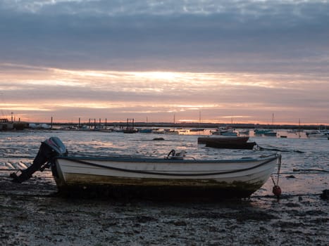 sun set sky dramatic clouds sea front beach harbor marina boats moored landscape; west mersea, essex, england, uk