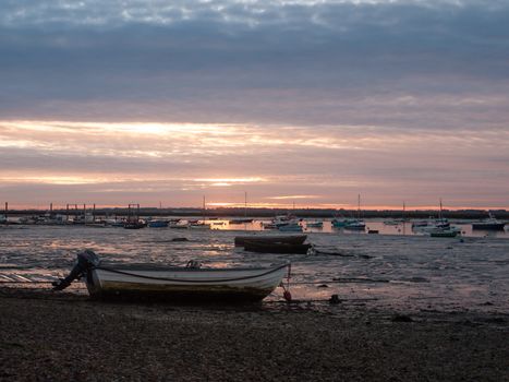 sun set sky dramatic clouds sea front beach harbor marina boats moored landscape; west mersea, essex, england, uk