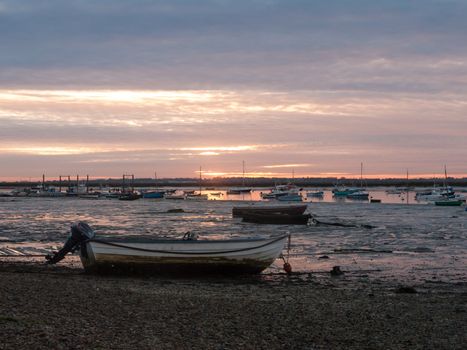 sun set sky dramatic clouds sea front beach harbor marina boats moored landscape; west mersea, essex, england, uk