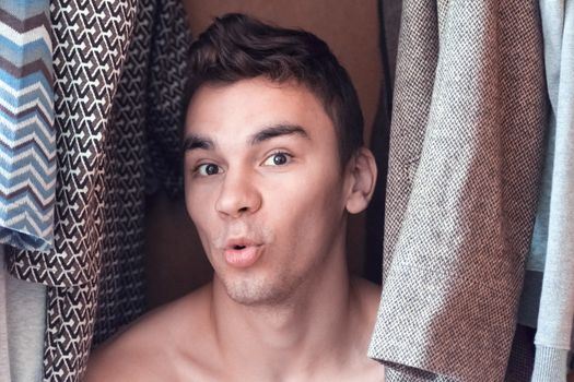a young man hiding in the closet women's clothing