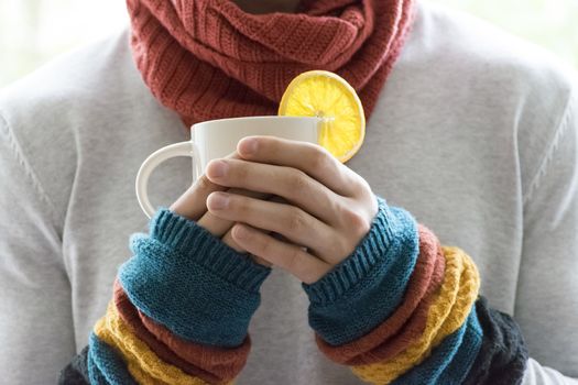 A young man holding a Cup of tea and lemon. Cold, cold, disease.