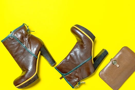 Female shoes, bag, autumn leaves on a yellow background. The concept of autumn.