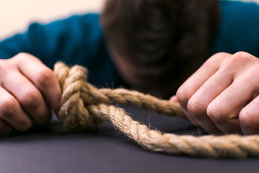 A man holds a loop of rope in his hands. A mental health day.