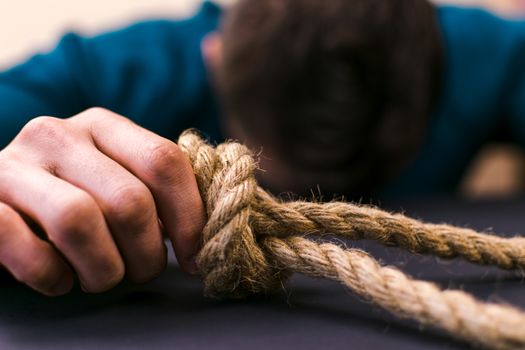 A man holds a loop of rope in his hands. A mental health day.