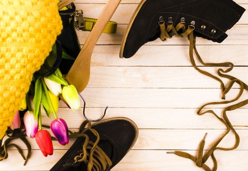 Women's bag with clothes and shoes on a colored background