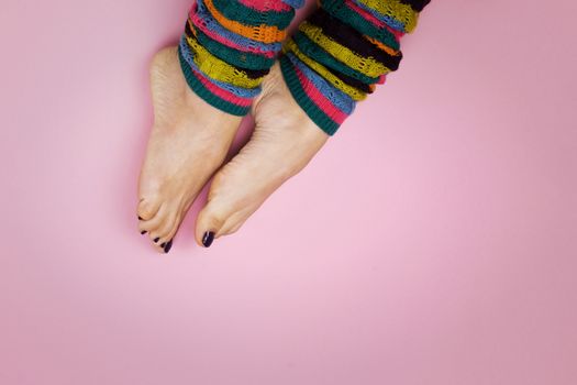 Female feet in socks on a pink background