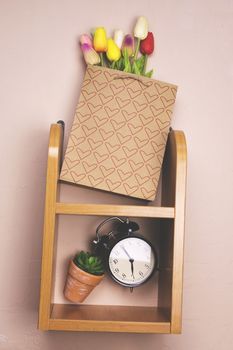 Shelf on the wall with flowers and clock