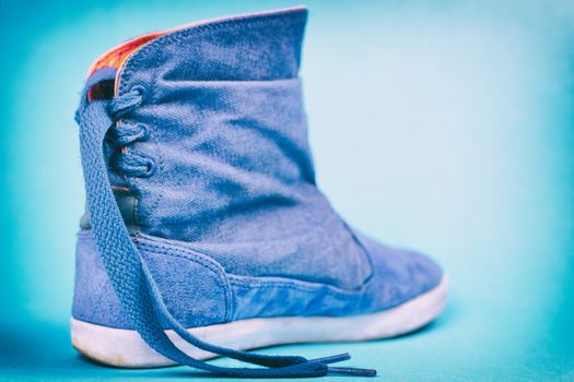 Women's denim boots on a colored background