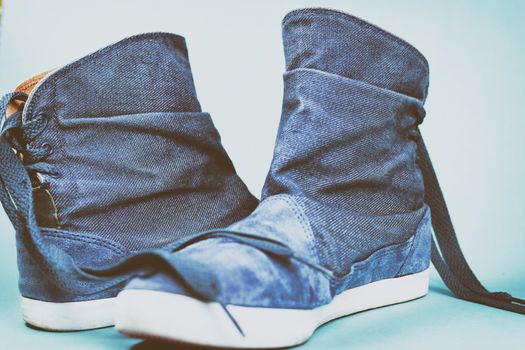 Women's denim boots on a colored background