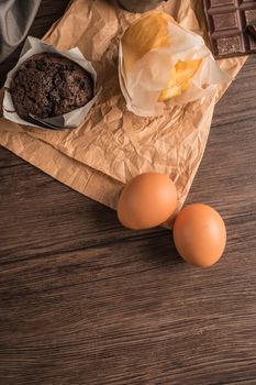 Homemade muffins with chocolate and baking ingredients.