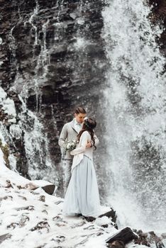 bride and groom on the background of a mountain waterfall