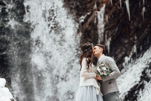 bride and groom on the background of a mountain waterfall