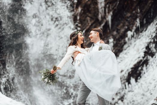 bride and groom on the background of a mountain waterfall