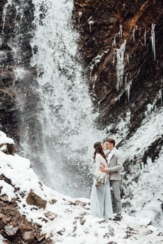 bride and groom on the background of a mountain waterfall