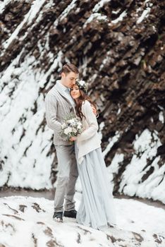 bride and groom on the background of a mountain waterfall